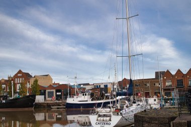 Arka planında kırmızı tuğla duvar olan küçük bir tekne.