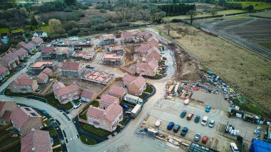 Konut ve şantiyeli bir yerleşim alanının havadan görünüşü, banliyölerin genişlemesini gösteriyor.