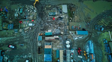 Dağınık ekipman ve malzemelerle donatılmış bir sanayi bölgesinin hava görüntüsü.