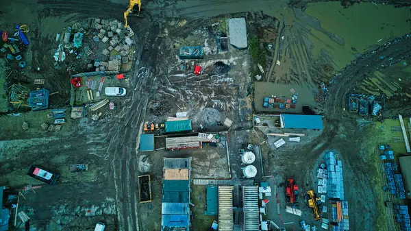 Dağınık ekipman ve malzemelerle donatılmış bir sanayi bölgesinin hava görüntüsü.