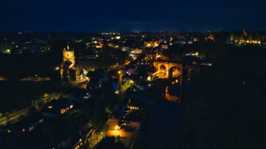 Aydınlatılmış binaları ve caddeleri olan şehir manzarası, Knaresborough, Kuzey Yorkshire 'da kentsel mimari sergileniyor.