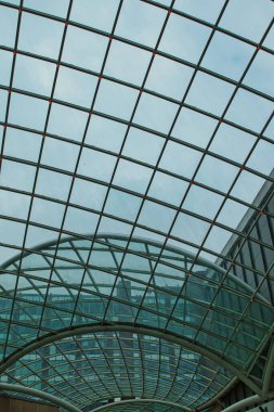 Leeds, İngiltere 'de mavi gökyüzüne karşı geometrik desenli modern cam tavan mimarisi.