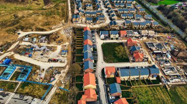 Harrogate, North Yorkshire 'da inşaat alanlarını ve tamamlanmış kırmızı çatıları olan evleri gösteren sıra sıra evleri olan bir banliyö yerleşim alanı manzarası..