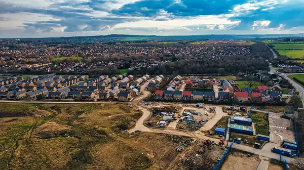 Aerial view of a suburban development with houses and roads, showcasing urban expansion into rural areas in Harrogate, North Yorkshire.
