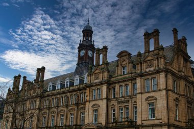 Leeds, İngiltere 'de dramatik bulutlu bir gökyüzü altında saat kulesi olan tarihi Avrupa mimarisi.
