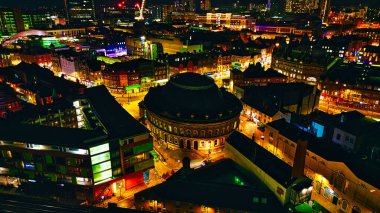Aydınlatılmış binalar ve inşaat vinçleriyle gece şehir manzarası Leeds, İngiltere 'de kentsel gelişim sergileniyor..