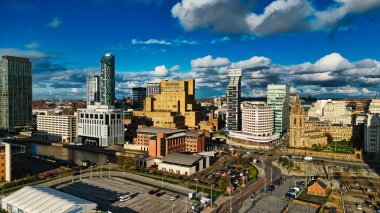 Liverpool, İngiltere 'de mavi gökdelenlerin altında tüylü bulutlarla modern gökdelenlerle panoramik şehir manzarası.