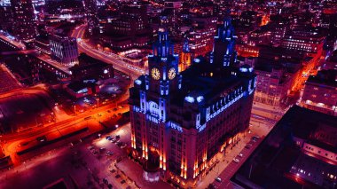 Liverpool, İngiltere 'de şehir sokaklarının ortasındaki aydınlık kırmızı trafiği gösteren tarihi bir binanın gece görüşü..