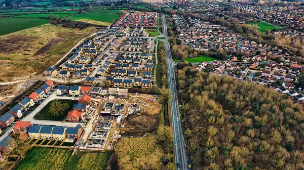 Aerial view of suburban housing development with new construction, roads, and green fields in Harrogate, North Yorkshire.