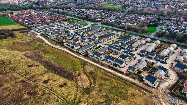 Aerial view of a suburban housing development with rows of houses next to open land in Harrogate, North Yorkshire.