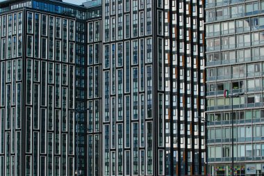 Gökyüzünü yansıtan pencereleri olan modern cam ofis binaları, Liverpool, İngiltere 'de şehir mimarisini gözler önüne seriyor..