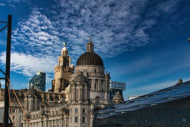 Liverpool 'un ikonik deniz manzaralı binaları mavi gökyüzünün altında ince bulutlu..