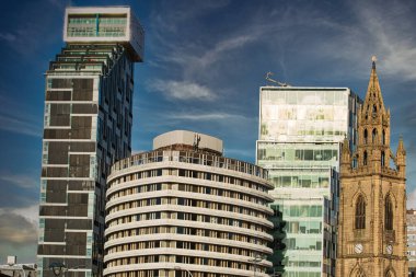 Modern şehir silueti, çağdaş binalar ve tarihi bir kilise karışımı mavi gökyüzü altında Liverpool, İngiltere 'de bulutlu..