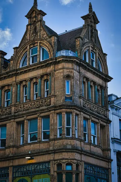 Victorian architecture with ornate details on a historic building\'s facade against a blue sky in Leeds, UK.
