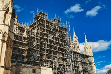 Tarihsel katedral yenileniyor. Bulutlu, parlak mavi gökyüzüne karşı karmaşık bir iskelesi var. York, Kuzey Yorkshire, İngiltere 'de mimari koruma kavramı.