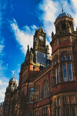 York, Kuzey Yorkshire, İngiltere 'de bulutlu mavi gökyüzü üzerinde belirgin bir saat kulesi bulunan tarihi bir binanın Gotik mimarisi..