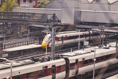 Kalabalık trenleri olan modern bir tren istasyonunun hava görüntüsü, işlek bir şehir taşıma merkezini gösteriyor..