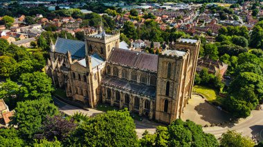 Ağaçlar ve konut binalarıyla çevrili büyük tarihi bir katedralin havadan görünüşü. Katedral, küçük bir kasabanın arka planına karşı uzun kuleleri ve geniş pencereleri olan karmaşık bir mimariye sahip..