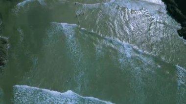 İngiltere, Cornwall 'da büyük bir plajdaki dalgaların hava videosu.