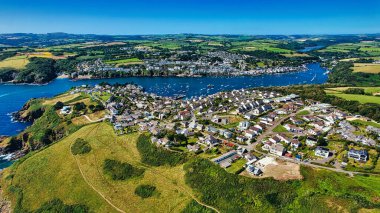 Etrafı yemyeşil tepelerle ve teknelerle dolu sakin bir limanla çevrili pitoresk bir sahil kasabasının havadan görünüşü. Kasaba, doğanın ve mimarinin güzelliğini gözler önüne seren konut evleri ve manzaraların bir karışımına sahip..