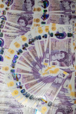20 poundluk banknotların bir hayranı spiral bir düzende dizayn edilmiş, paranın karmaşık dizaynlarını ve renklerini gözler önüne seriyor. Notlarda Kraliçe II. Elizabeth ve holografik elementlerin güvenlik özelliklerini vurgulayan bir portresi yer alıyor..