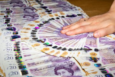 İngiliz 20 banknot hayranının üzerinde dinlenen bir el, renkli tasarımı ve para biriminin holografik özelliklerini gözler önüne seriyor.. 