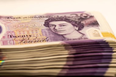 Kraliçe 2. Elizabeth 'in portresi ve 20 Pound yazılı bir yığın İngiliz banknotunun yakın çekimi..