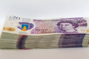 Kraliçe Elizabeth 'in portresi ve Bank of Englands logosunun yer aldığı düzgünce istiflenmiş 20 pound' luk İngiliz banknotları. Resim para biriminin ayrıntılarını ve güvenlik özelliklerini yakalar.