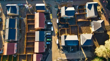 İnşaat halindeki yeni bir konutun havadan görünüşü. Evler tamamlanmanın çeşitli aşamalarında yer alırken, bazıları çıplak temelleri gösteriyor ve diğerleri neredeyse tamamlanmak üzere. Arabalar Knaresborough, İngiltere 'de caddeye park edilmiş..