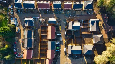Konut inşaatı alanının havadan görüntüsü. Knaresborough, İngiltere 'de toprak işçileri, araçlar ve inşaat ekipmanlarıyla çevrili, çeşitli tamamlanma aşamalarında sayısız ev..