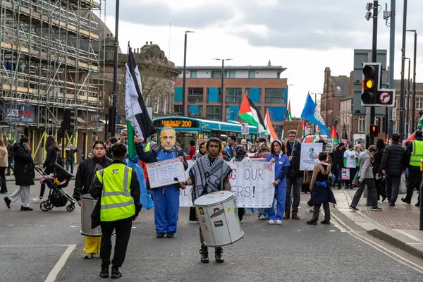 Şehirdeki siyasi bir gösterinin sokak seviyesinde çekimi. Tabelalar, bayraklar ve bir davulcuyla..