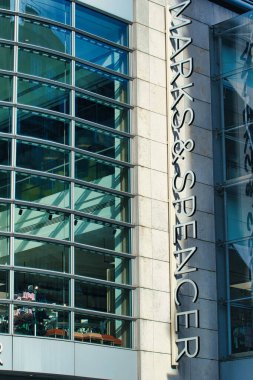 Bir Marks & Spencer mağazasının dış görüntüsü, bir cam cephe ve Manchester, İngiltere 'de bir taş duvarda mağazanın tabelası sergileniyor..