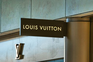 Markanın logosu Manchester, İngiltere 'deki dokulu, tarafsız bir bina cephesine iliştirilmiş Louis Vuitton mağaza tabelasının yakın çekimi..