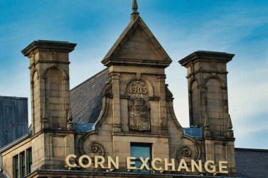 Mısır Borsası binasının mimari detayları. İçinde taş kuleler, oyulmuş detaylar ve mavi gökyüzüne karşı işaretler var..