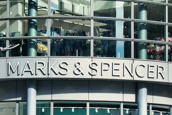 Bir Marks & Spencer mağaza önü dış çekim büyük cam pencereler iç görüntüler yansıtan Manchester, İngiltere 'de gökyüzü.