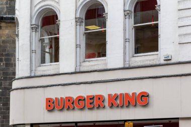 Burger King mağazasının dış görünüşü. Tabelanın üzerinde kemerli pencereler var. Binanın bir taş cephesi ve Leeds, İngiltere 'de görünür bir güvenlik sistemi var..