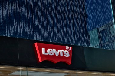 Levi 's mağaza tabelasını kapatın, siyah arka planda kırmızı beyaz logo, arkasında da Liverpool, İngiltere' deki koyu mavi bina cephesi var..