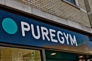 Bir binada orta boy bir PüreGym tabelası. İşaret, beyaz harfli lacivert ve Wimbledon, Londra, İngiltere 'de bir deniz mavisi dairesi..
