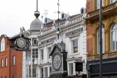 Bir sokak manzarası, Leeds, İngiltere 'de bulutlu bir gökyüzüne karşı, çeşitli mimari tarzlara sahip çeşitli binalar, saatler ve dekoratif unsurlar sergiliyor..