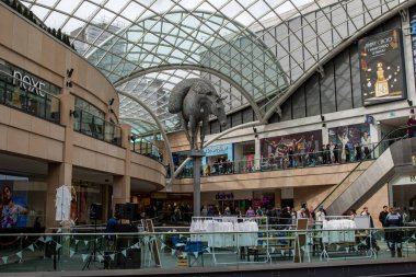 Metal at heykelleri, çeşitli dükkanlar ve Leeds, İngiltere 'deki insanların bulunduğu çok katlı bir alışveriş merkezinin iç görünümü..