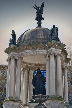 İngiltere 'nin Liverpool şehrinde bulutlu bir gökyüzünün altında sütunları ve ek heykelleri olan kubbeli bir yapıda Kraliçe Victoria heykeli..