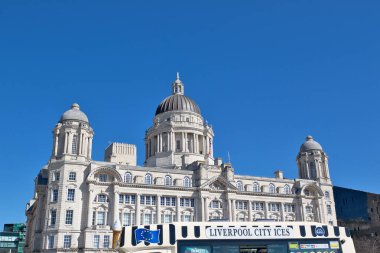 Görüntü Liverpool Limanı 'nı gösteriyor. Mavi gökyüzünün altında, önplanında Liverpool City Ices aracı var..