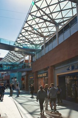 Yayalar, perakende mağazaları, metal ve cam tepe örtüsü ve parlak bir günde Liverpool, İngiltere 'de bir yaya köprüsünün yer aldığı açık hava alışveriş alanı..