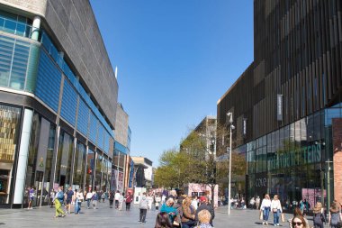 Modern binalar arasında yürüyen insanların olduğu şehir sokak manzarası, Liverpool, İngiltere 'de açık mavi gökyüzü.