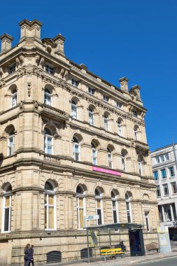 Güneşli bir günde süslenmiş kumtaşı bir binaya bakarken çekilmiş bir fotoğraf. Liverpool, İngiltere 'de bir otobüs durağını gösteriyor..