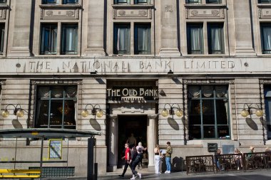 Açık gri taştan bir bina, eski adıyla Ulusal Banka, şimdi Eski Banka. İngiltere, Liverpool 'da insanlar kaldırımda yürür..