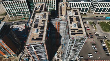 Güneş panelleri, iskelesi ve inşaat ekipmanları, Leeds, İngiltere 'deki arabalar ve yollar da dahil olmak üzere birden fazla binanın havadan görüntüsü..