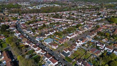 Morden, Londra, İngiltere 'de evleri, yolları, ağaçları ve araçları olan yoğun nüfuslu bir banliyö bölgesinin hava görüntüsü..