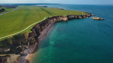 Marsden Sahili, İngiltere 'de yeşil tarlaları, uçurumları, yürüyen bir yolu ve turkuaz okyanusu olan bir sahil manzarası..