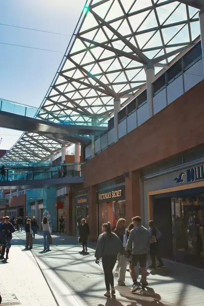 Yayalar, perakende mağazaları, metal ve cam tepe örtüsü ve parlak bir günde Liverpool, İngiltere 'de bir yaya köprüsünün yer aldığı açık hava alışveriş alanı..